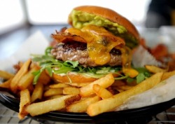 everybody-loves-to-eat:  Avocado bacon burger with fries.