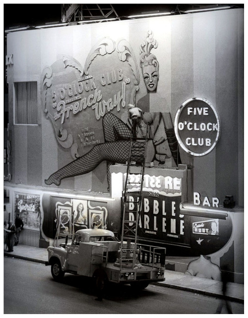 In a press photo dated from the mid-1950′s, a worker can be seen making repairs to the signage at Martha Raye’s Original ‘5 O’CLOCK CLUB’ ; located at 215 22nd Street (at Collins Avenue), in Miami Beach.. Burlesque dancers Tee Tee Red and