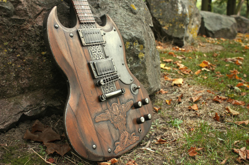 glorifiedguitars:  The Norse SG, featuring carvings of Odin with his two ravens Huginn and Muninn and his two wolves Geri and Freki.This beautiful piece of art was created by the talents at Hutchinson Guitar Concepts. 