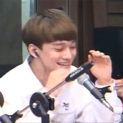 :  Kim Jongdae, smiling, rubbing his eyes, and playing with his