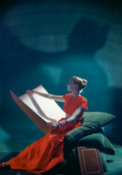 bookpatrol:  Model holding large folio wearing two-piece hostess