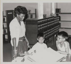 vintagelibraries:  Library staff helping two boys look up words