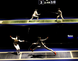 modernfencing:  [ID: a photo of two foil bouts, happening simultaneously