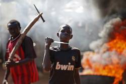 politics-war:  A boy brandishes a knife as he stands in front