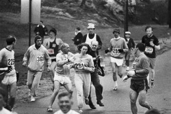 Organizers try to stop the first woman arriving at a marathon,