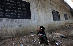  A girl takes notes from a blackboard painted on a wall at a