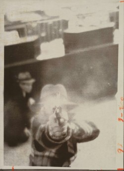 bowlersandhighcollars:  A bank robber aiming at a security camera.