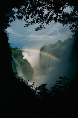 natgeofound:  A rainbow arches over Victoria Falls in Zimbabwe.