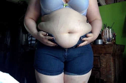 pudgebelly:  This is my encourager/feedee trying on some shorts she says fit fine just last summer. You know, before she started talking to me and has since gained almost 50 pounds in a year… Show her some love, she’s so wonderful she deserves all