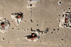 Palestinian children look out from their family’s house, which