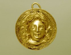 via-appia:  Gold shield-shaped pendant decorated with a female