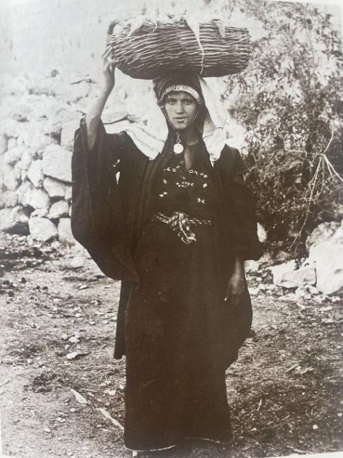 Palestinian woman carrying vegetables to sell in the markets