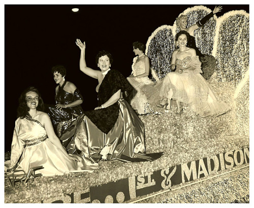 Gay Dawn waves to the crowd from the very top of a float promoting the ‘RIVOLI Theatre’; in Seattle, Washington.. The parade was an annual event (sponsored by the local Chamber Of Commerce) and part of the city’s “Sea Fair week&rdq