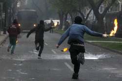 politics-war:  Protesters run holding Molotov cocktails to throw