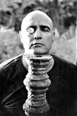 Marlon Brando resting his chin on a pedestal with a Soda bottle