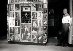 Vintage photo dated from July of &lsquo;41, features a wary employee standing at the entrance of an unidentified Burlesque theatre; located somewhere on S. State Street in Chicago..