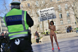 bintphotobooks:    A policeman looks on as performance artist