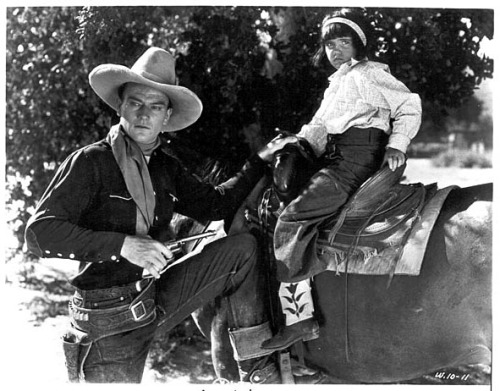   A very young Shirley Jean Rickert poses for a publicity still to 1934’s ‘Neath Arizona Skies’, starring an equally young John Wayne.. She played the role of “Nina”, the little indian girl.. 20 years later, she’d begin performing as a feature