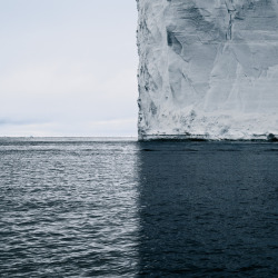 itscolossal: A Towering Iceberg and Its Shadow Split the World