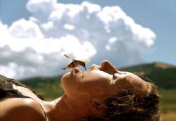 blua:  A humming bird drinking from the mouth of a person in