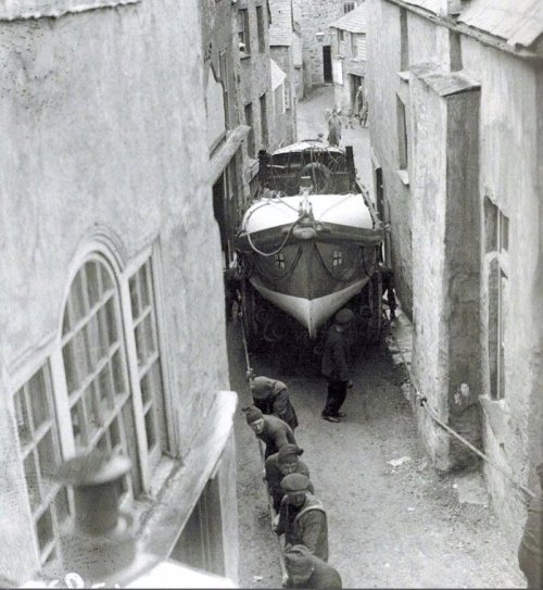 Sailors pull the boat through the narrow streets of the town