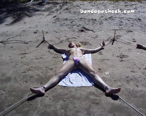 sirrendre:  two young women staked out topless on the beach   Bondage by the beach!