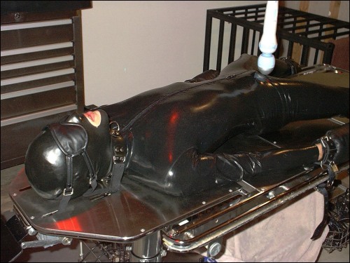 do-not-open-til-christmas:  strappedown:  The rubber suit is thin and very stretchy…your cock will have no trouble getting hard in it.  You’ll find it hard to move or slide away, however, the rubber does have a way of gripping to that table I’ve