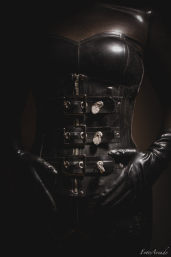 fotoarcade:  rubber corset with locking buckles over a latex