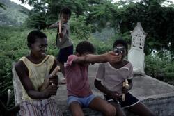 Children play with make-shift guns in a cemetery, Grenada 1979,