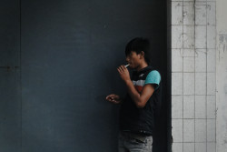 Man smokes in the street. Bandung, Indonesia