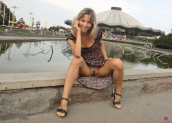 Lovely girl sitting on the edge of a pool wearing no panties