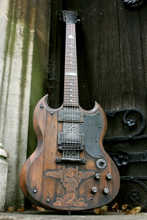 glorifiedguitars:  The Norse SG, featuring carvings of Odin with his two ravens Huginn and Muninn and his two wolves Geri and Freki.This beautiful piece of art was created by the talents at Hutchinson Guitar Concepts. 