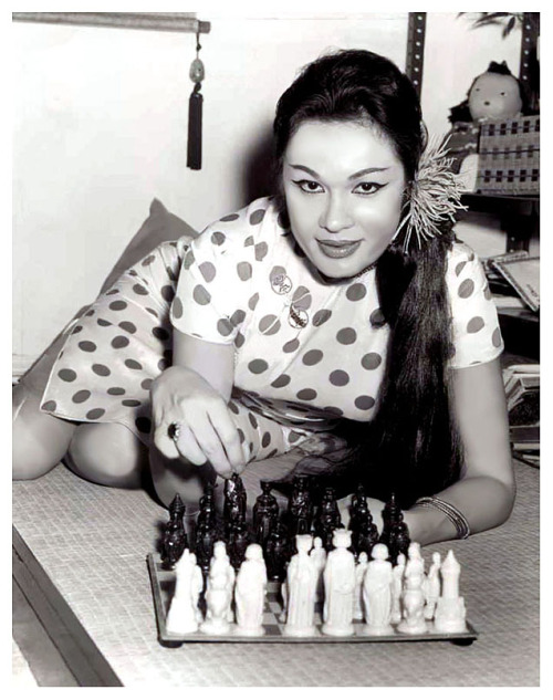  Danielle Dao Tien     aka. “The Eurasian Beauty”.. Vintage press photo dated from 1962 features Ms. Dao Tien playing chess, as she claimed to be unable to find work as an exotic dancer.. While dancing in Miami, she’d incurred the