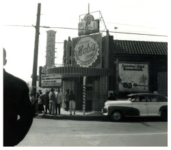 Vintage 40’s-era photo features patrons standing underneath the marquee of the &lsquo;EL RANCHO Café’ nightclub; located somewhere in Mexico.. 