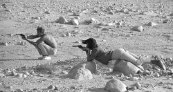 Steve McQueen and his wife, Neile Adams, firing pistols in the