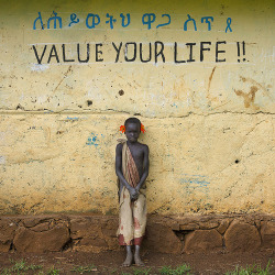 tapio-ca:  Suri Boy Leaning against a wall covered with Amharic