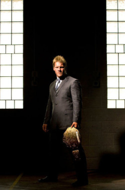 Jericho in a dark alley, wearing a suit with the world title!