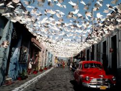 natgeotravel:Paper birds fill the sky above a street during the