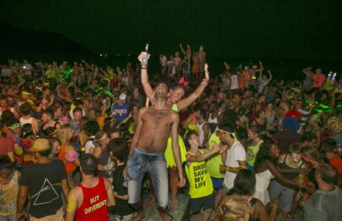 Thousands of people from around the world pack Haad Rin Beach, Koh Phangan, Thailand on August 22 2013 for the annual Full Moon Party, enjoying the cheap liquor and drugs in an all night affair. The full moon party started in late 1988 and has become