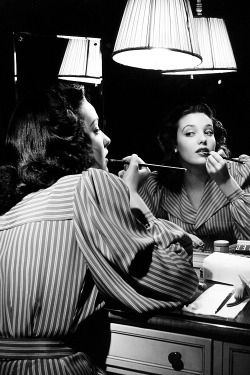 Linda Darnell putting on make-up in mirror, photographed by Herbert