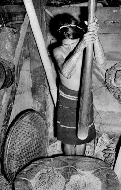 Tattooed Igorot woman with mortar and pestle on northern Luzon