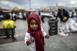 letswakeupworld:A Syrian refugee girl eats food that her mother