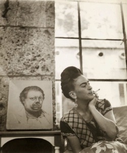 frida-kahlo:Frida Kahlo frente a un autorretrato de Diego Rivera.