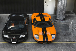 topvehicles:  Black Bugatti Veyron beside an Orange Ford GT Source