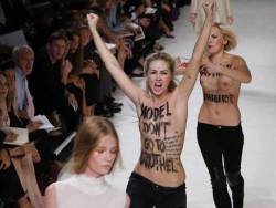 Activists of the feminist movement FEMEN protest on the catwalk