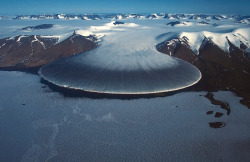blazepress:A glacier flowing over mountains.