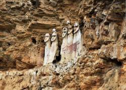 Eight  sarcophagi containing mummies standing on the cliff side,