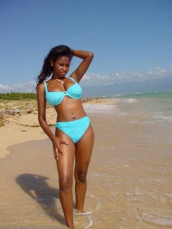 Brown skinned beauty with big tits strips on the beach and shows