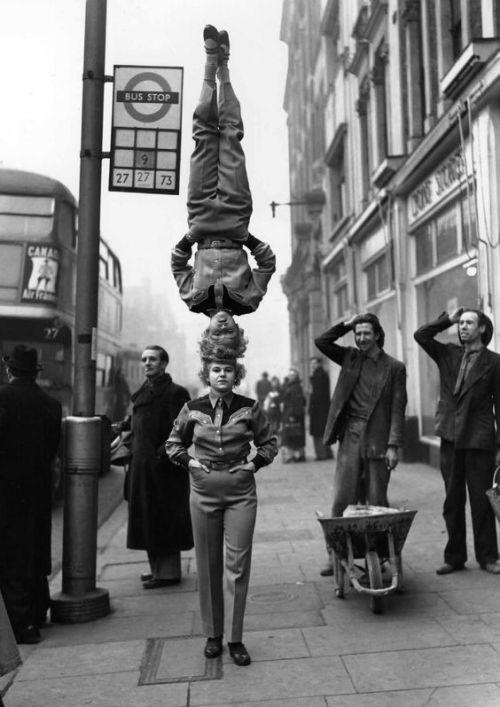 emmaklee:two members of a circus walking down a London street,