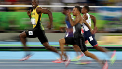 Usain Bolt smiles for the camera as he wins the Olympic 100 metres